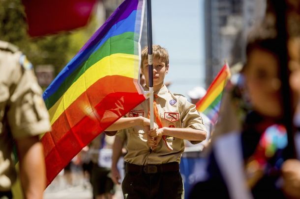 Un boy scout porta la bandera del orgullo gay