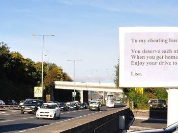 Mujer escracha a su marido infiel con un enorme cartel en la autopista