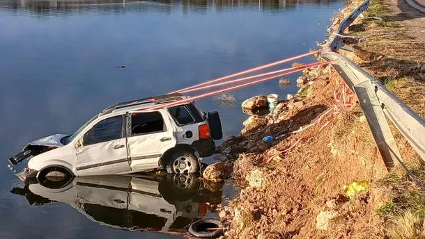 La camioneta atravesó la calzada, superó el guardarraíl y quedó sumergida en una depresión inundada. La camioneta atravesó la calzada, superó el guardarraíl y quedó sumergida en una depresión inundada.