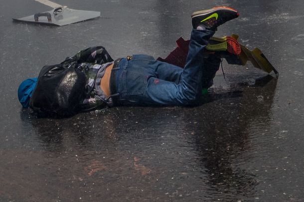 Un joven caído en el asfalto durante las protestas en Venezuela