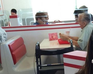 El hombre que come junto a la foto de su mujer
