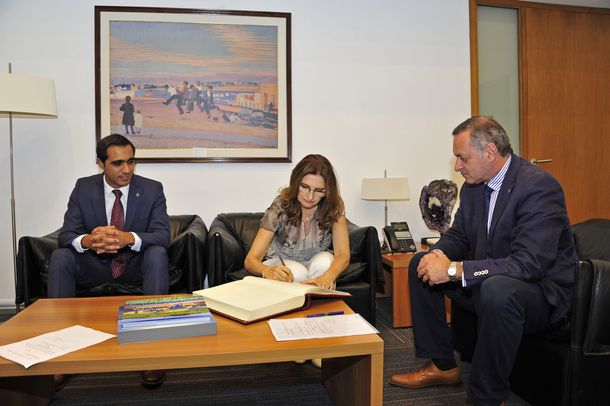 Karina Rando rubricando su firma ante la mirada del secretario de Presidencia