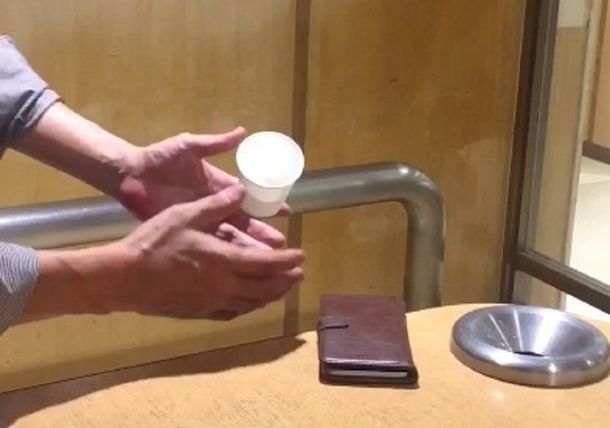 Un truco de magia donde una japonés hace levitar un vaso y un cigarrillo