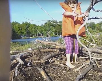 Una nena aventurera agarra sin miedo a una víbora