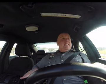 Policía bailando y cantando en su patrullero