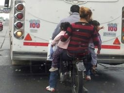 en moto con sus hijas colgadas en los brazos en moto con sus hijas colgadas en los brazos