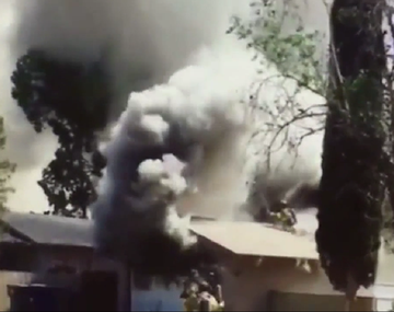 Un bombero cae de un techo en llamas