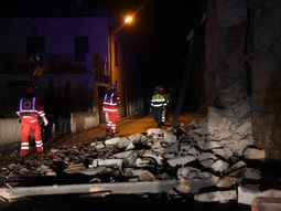 Un grupo de bomberos y rescatistas camina por los escombros Un grupo de bomberos y rescatistas camina por los escombros