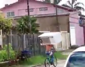 Se cargó una heladera en la cabeza y la llevó en bicicleta