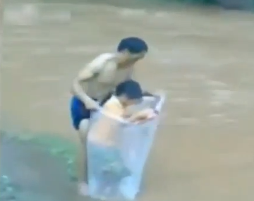 Insólito: mirá el momento en que niños cruzan el río en una bolsa para ir a la escuela