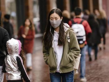 Una mujer camina con barbijo para protegerse del coronavirus Foto: América Económica