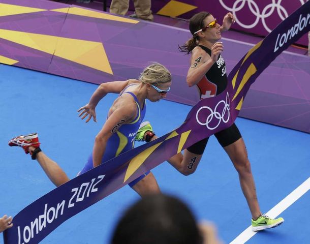 Nicola Spirig de Suiza (der) le gana a&nbsp; Lisa Norden de Suecia y obtiene la medalla dorada en triatlón