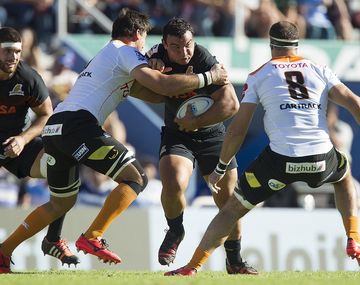 Agustín Creevy, encarando a dos rivales sudafricanos